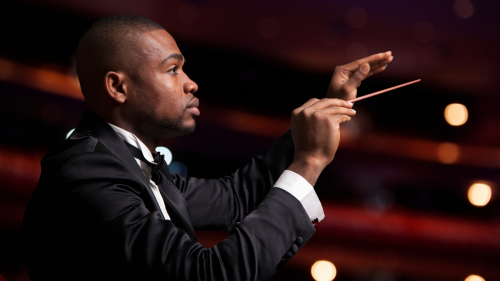 A black male conductor pictured in profile